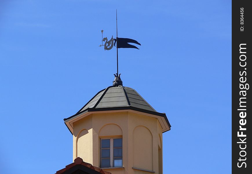 Weathercock against the background of blue sky