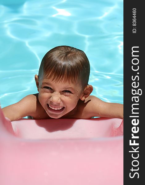 Boy smiling on a smimming pool slide