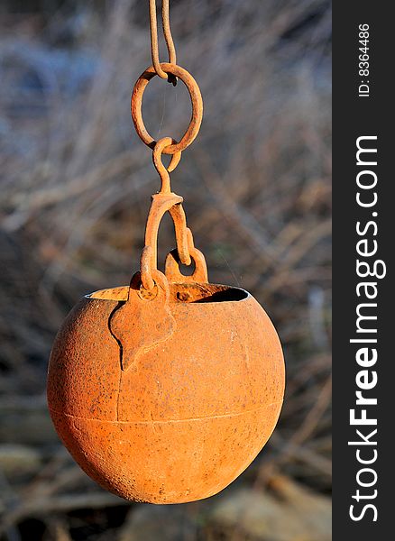 Metal vessel hanging outside in sun.