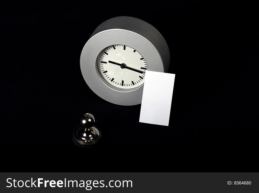 Card standing near modern clock and stamp. Card standing near modern clock and stamp