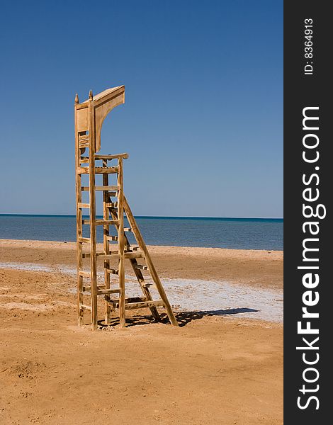 Empty baywatch seat on the beach. (lifeguard chair)