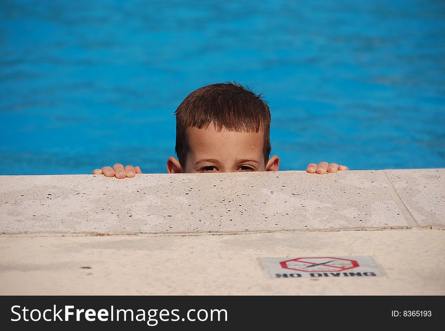 Boy Peeking Out Of A Pool