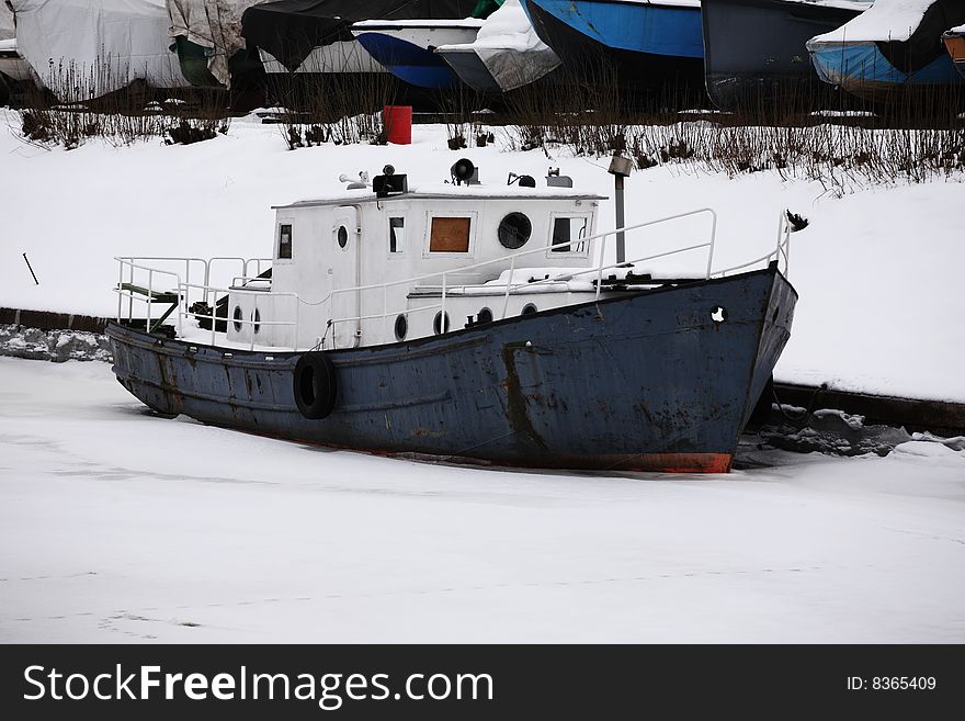 Abandoned boat in the ice river