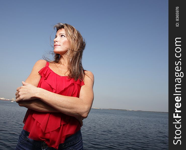Woman wearing a red shirt with a blue horizon in the background. Woman wearing a red shirt with a blue horizon in the background