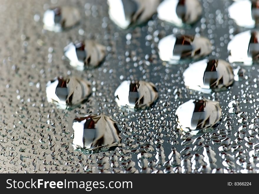 Brushed silver metallic background with silvery bubbles or drops.