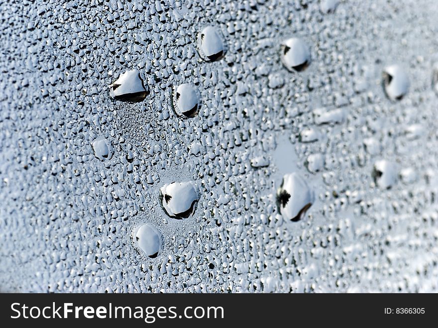Brushed silver metallic background with silvery bubbles or drops.