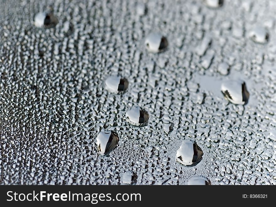 Brushed silver metallic background with silvery bubbles or drops.