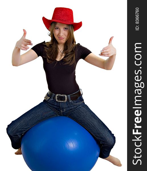 Girl in a western hat sitting on a large ball. Girl in a western hat sitting on a large ball