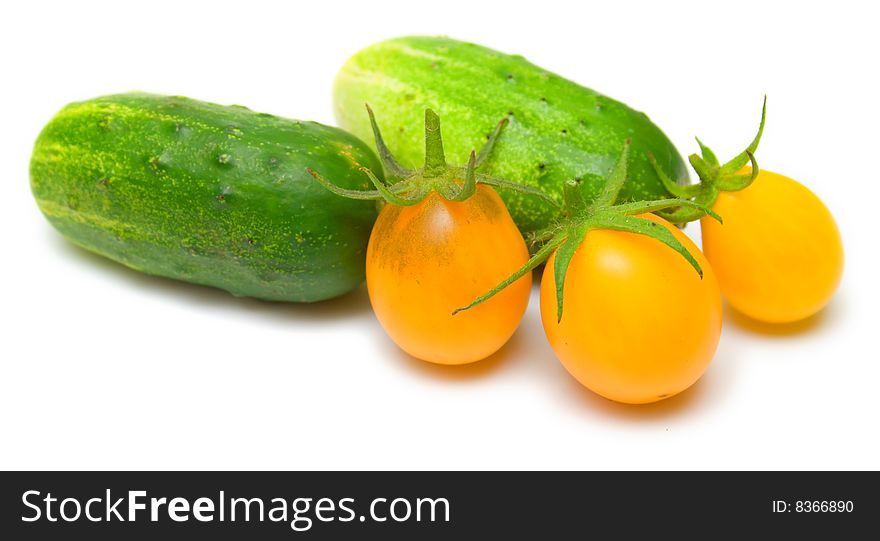 Green cucumbers and yellow tomatoes on white. Green cucumbers and yellow tomatoes on white