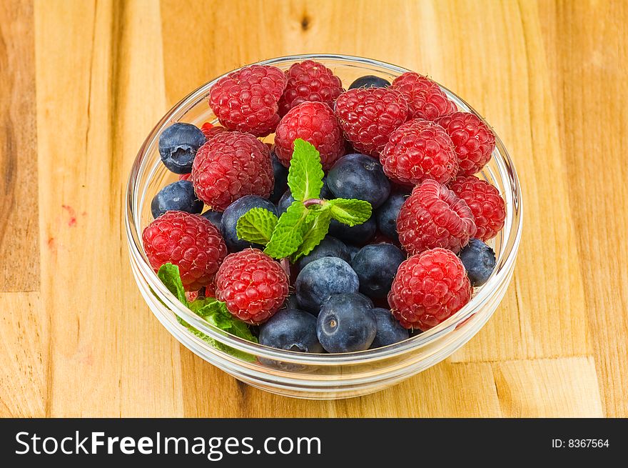 Fresh ripe raspberry and bluberry in glass jam-dish. Fresh ripe raspberry and bluberry in glass jam-dish