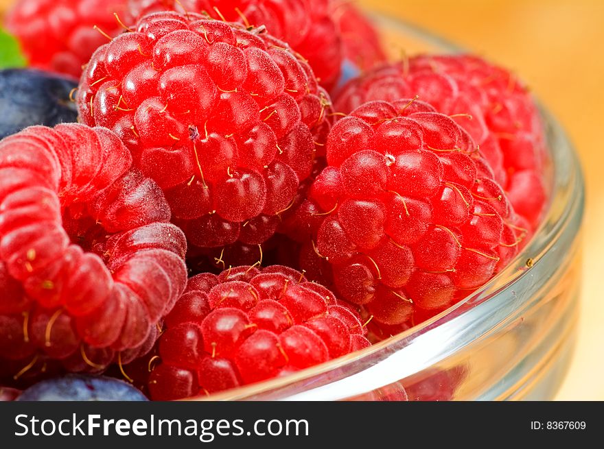 Fresh ripe raspberry and bluberry in glass jam-dish. Fresh ripe raspberry and bluberry in glass jam-dish