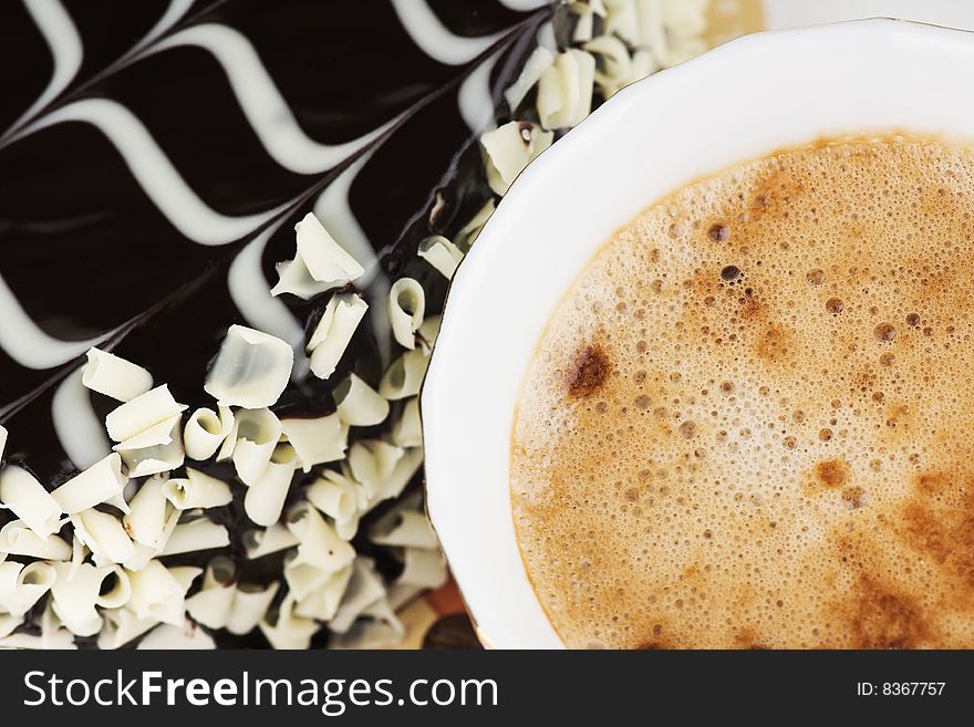 Cup of aromatic cappuccino with cake in the background. Cup of aromatic cappuccino with cake in the background