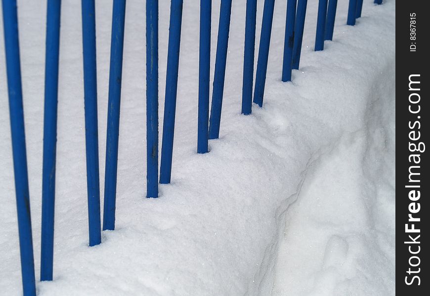 Blue iron railing in snow