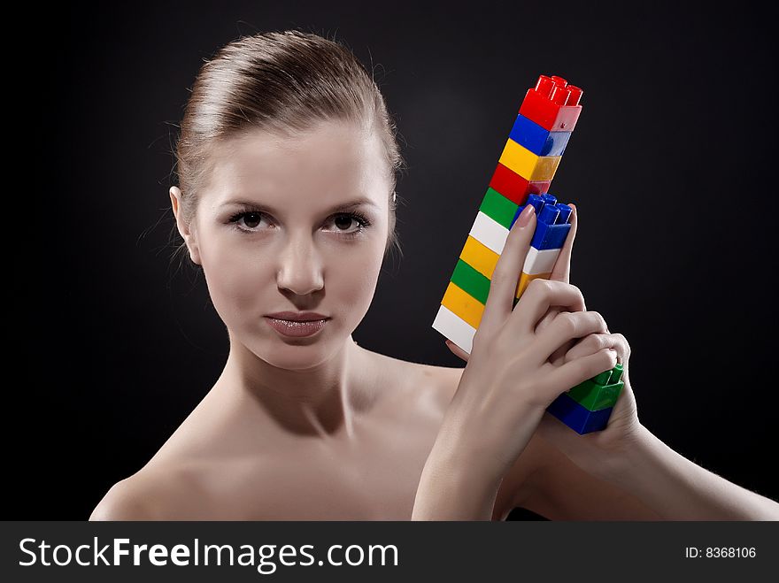 Portrait of young beautiful woman with toy gun