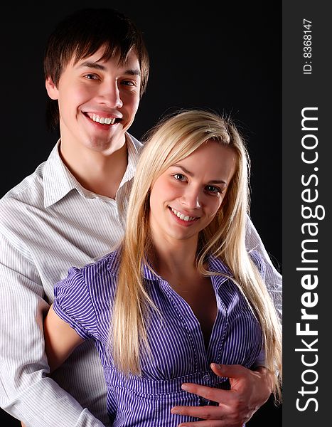 Young loving couple isolated at black background