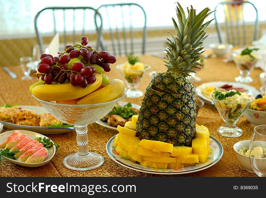 Pineapple, ripe bananas and other fruits and salads on holiday serve table. Pineapple, ripe bananas and other fruits and salads on holiday serve table.