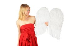 Blonde Girl In Red Dress Holds Angel S Wings Royalty Free Stock Photography