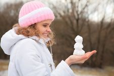 Young Beauty Girl In Winter Holds Small Snowman Royalty Free Stock Photography