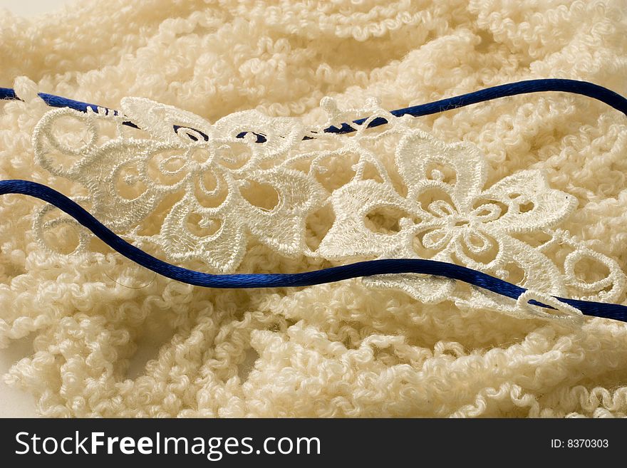 Blue ribbon and lace on beige wool. Blue ribbon and lace on beige wool