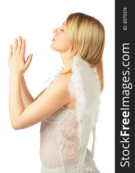 Girl in angel's costume prays on white background