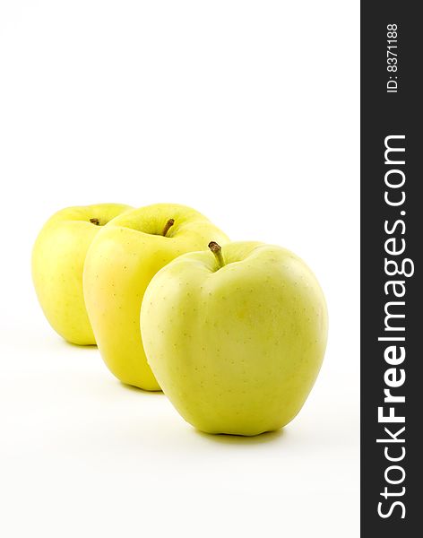 Three yellow apples in a row isolated on white background with copy space vertical