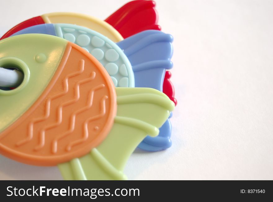 A close up of three colorful teether toys in fish shape