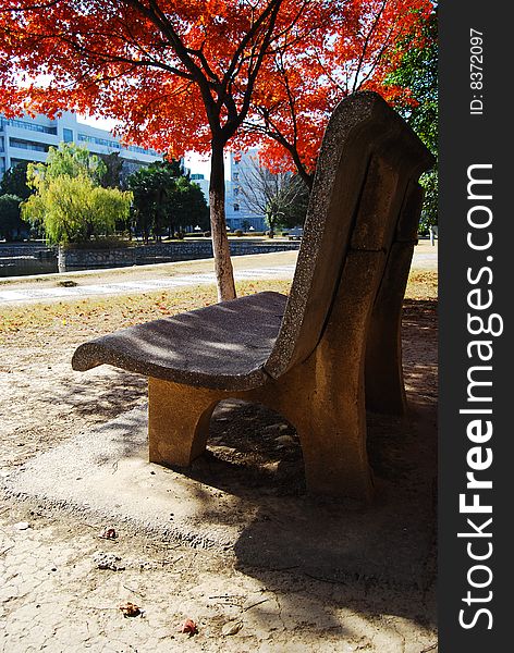 The Stone Chair In The Red Maple Leaf