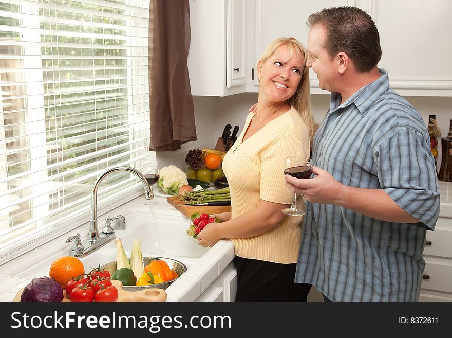 Happy Couple Enjoying An Eveing Preparing Food in the Kitchen.