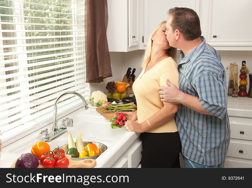 Happy Couple Enjoying An Eveing Preparing Food in the Kitchen.