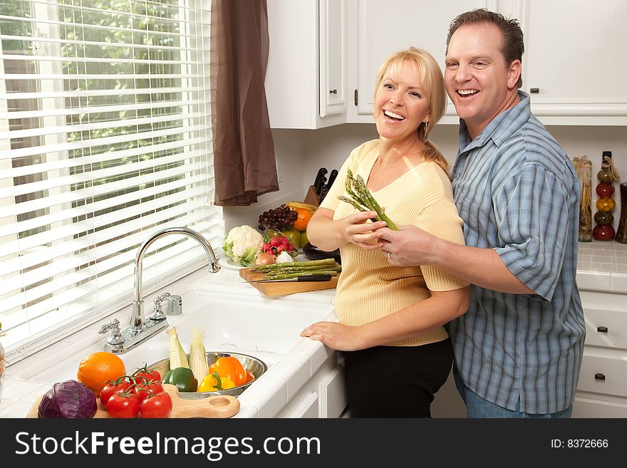 Happy Couple Enjoying An Eveing Preparing Food in the Kitchen.