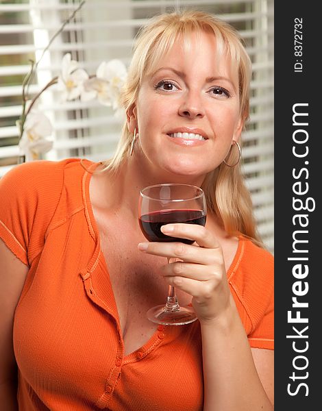 Attractive Blond with a Glass of Wine in the Kitchen