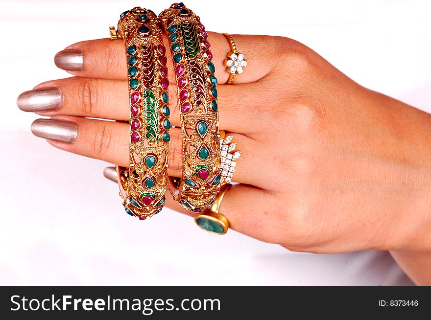 Golden bracelets and bangles on models hand.