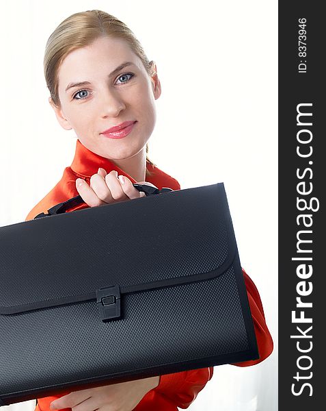 The beautiful girl in red holds in hands a black portfolio