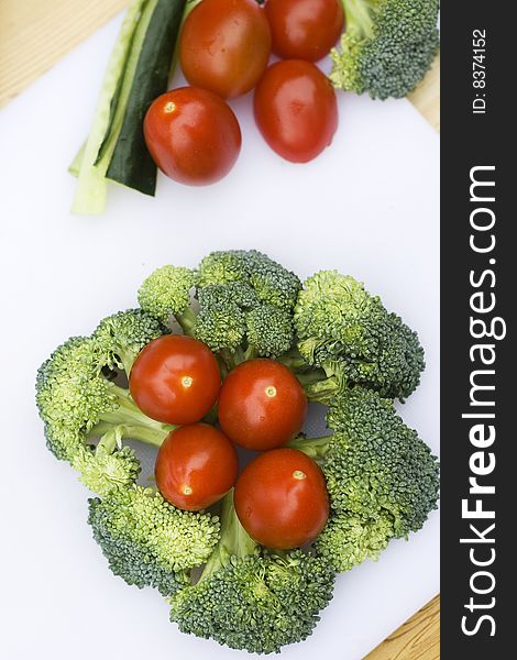 Vegetables that have been put into a pattern.  They are on a chopping board and are being prepared. Vegetables that have been put into a pattern.  They are on a chopping board and are being prepared.