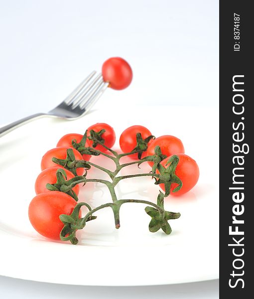 Tomatoes against a white background on a fork