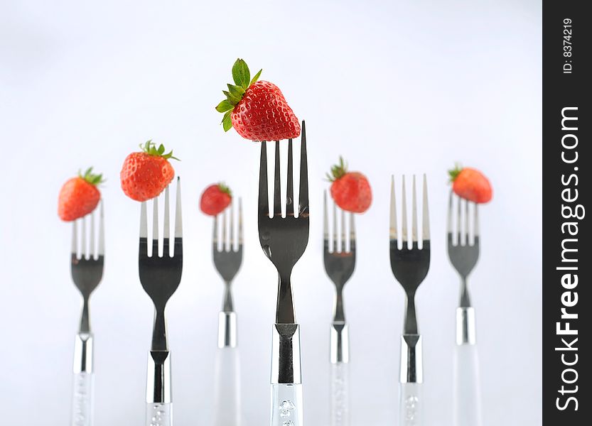 Strawberry with fork isolated on white background