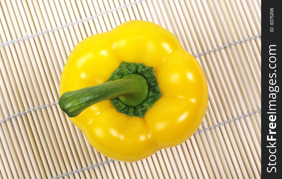 Yellow bell pepper on mat.