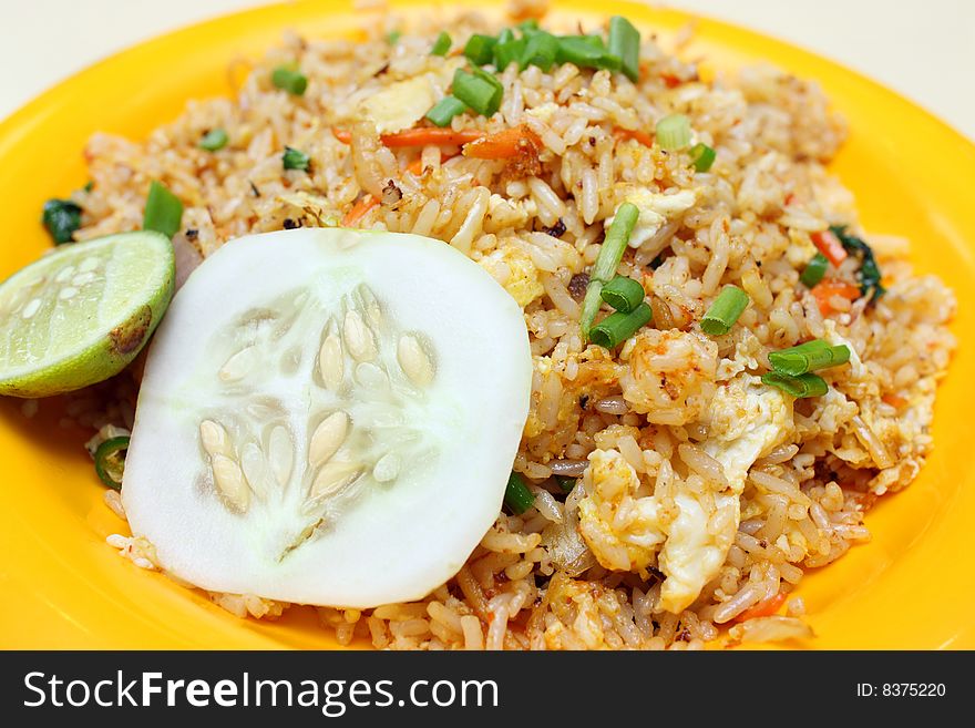 Close up of Indian fried rice on orange plate.