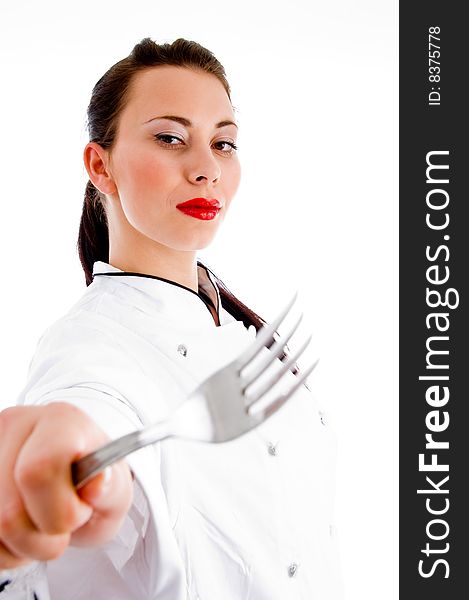 Young female chef showing fork with white background