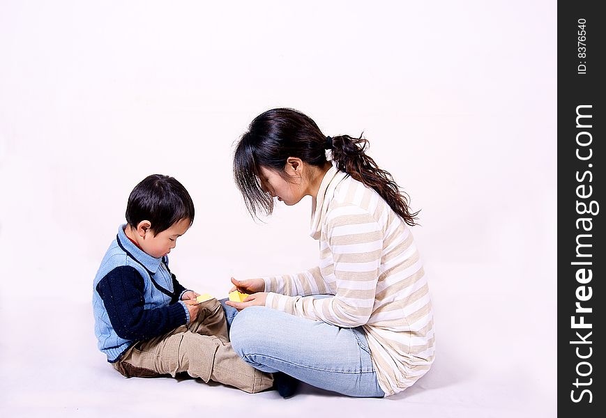a picture of a little chinese boy playing games with his mother and having great fun. a picture of a little chinese boy playing games with his mother and having great fun