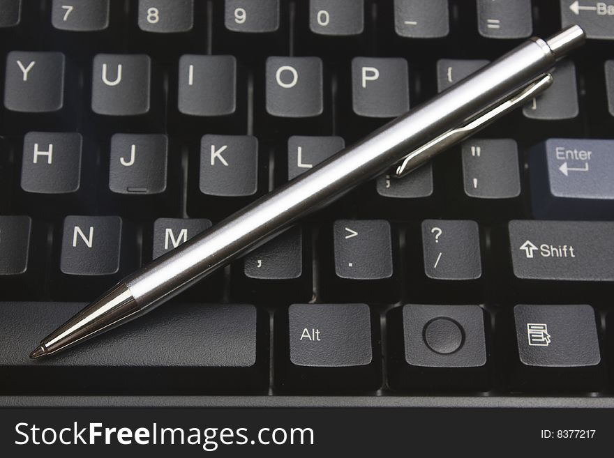 Business metal pen on black keyboard pc. Business metal pen on black keyboard pc