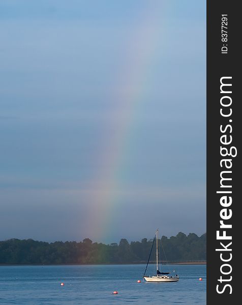 A yacht moored in a marina is where the rainbow ends. A yacht moored in a marina is where the rainbow ends