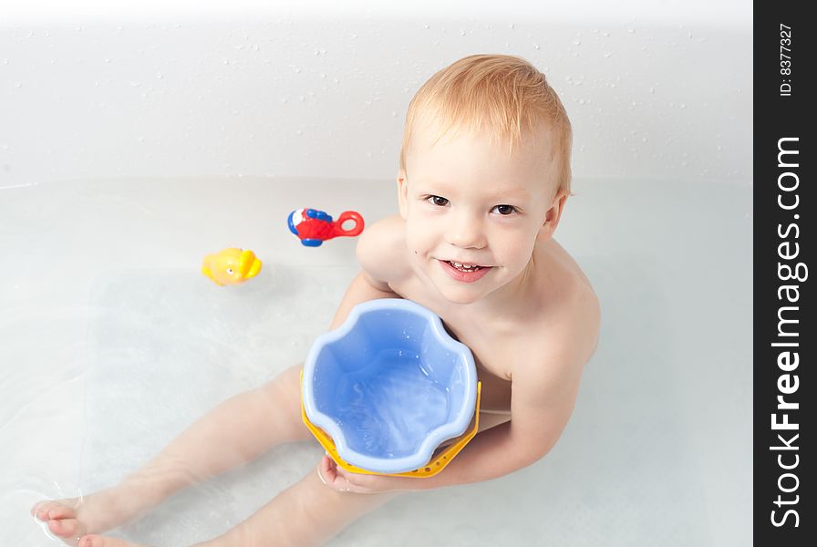 Baby in bath with bucket and toys. Baby in bath with bucket and toys