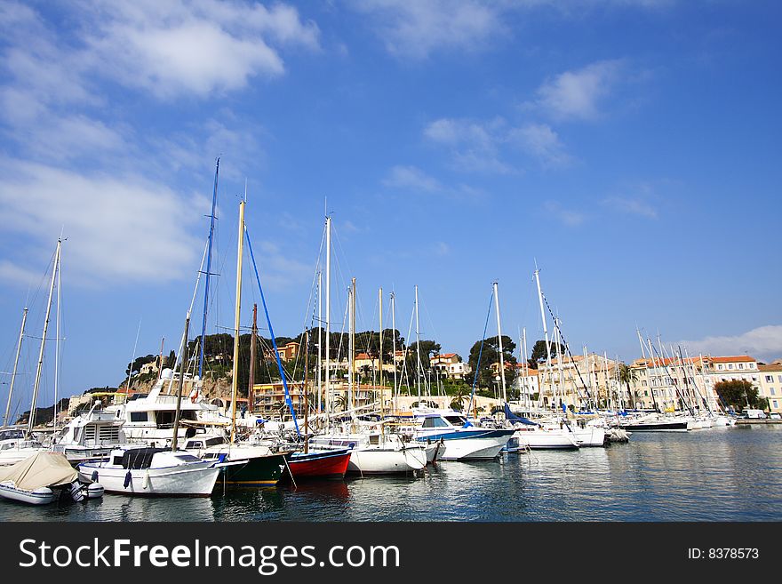 The typical port of sanary under a blue sky, a small mediterranean village in france during summer holidays. The typical port of sanary under a blue sky, a small mediterranean village in france during summer holidays