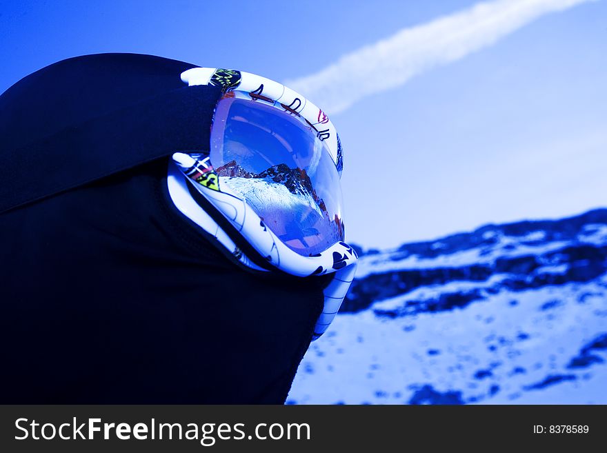 Skier with mountain peaks reflected on mask