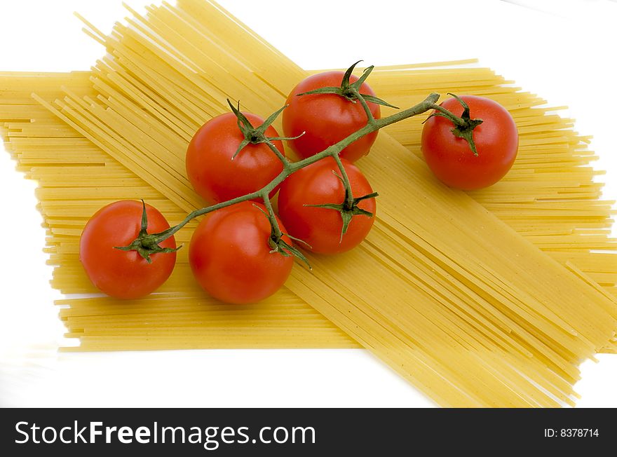 Branch of tomatoes lies on macaroni. Branch of tomatoes lies on macaroni