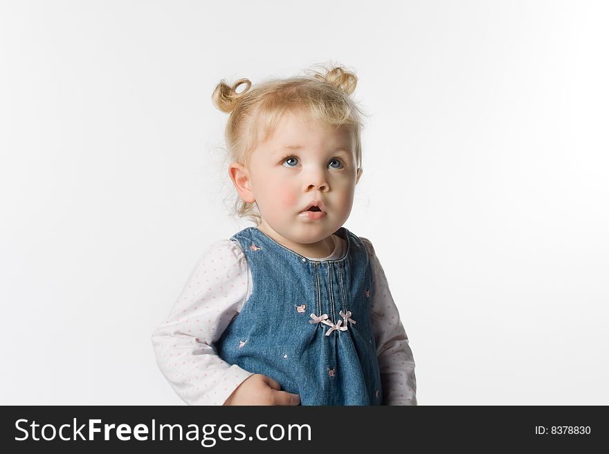 Adorable young girl looking up. She has pigtails. On a white background. Adorable young girl looking up. She has pigtails. On a white background.