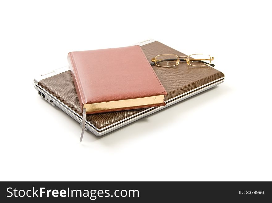 Laptop, note book and glasses isolated on white