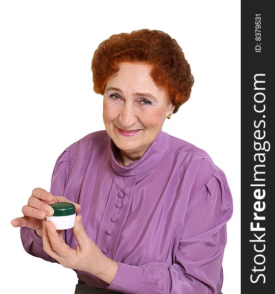 The elderly woman holds in a hand a jar with a cream. The elderly woman holds in a hand a jar with a cream