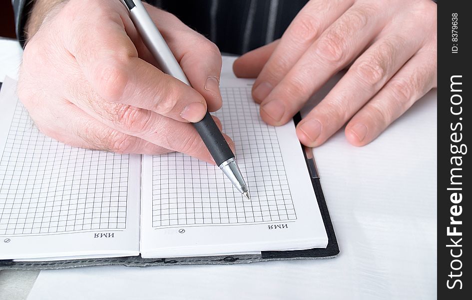 Closeup of mans hand going to write a business plan. Closeup of mans hand going to write a business plan